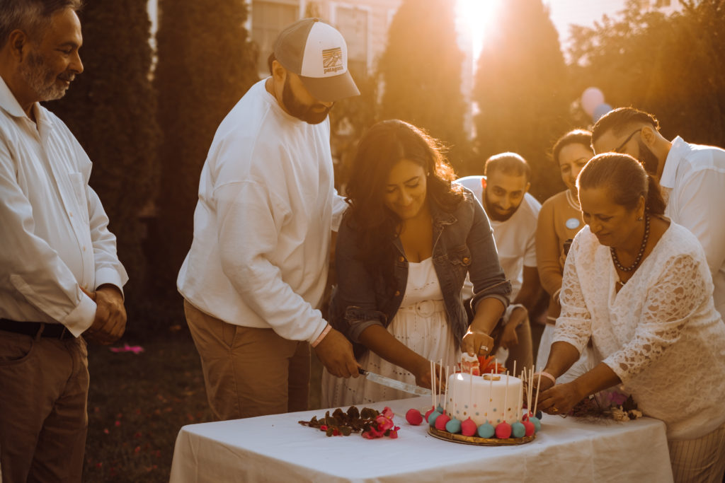 Indian couple cut pink cake at gender reveal