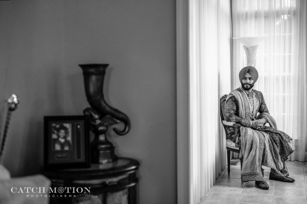 Black and white photo of seated Sikh groom