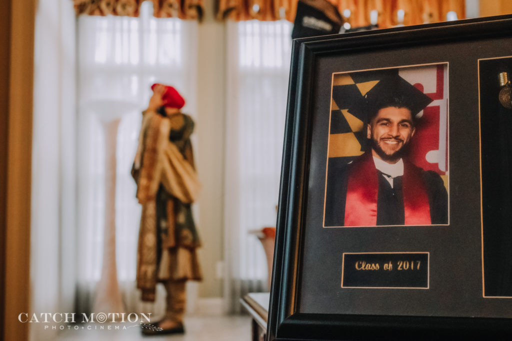 Groom gets ready behind his graduation photo